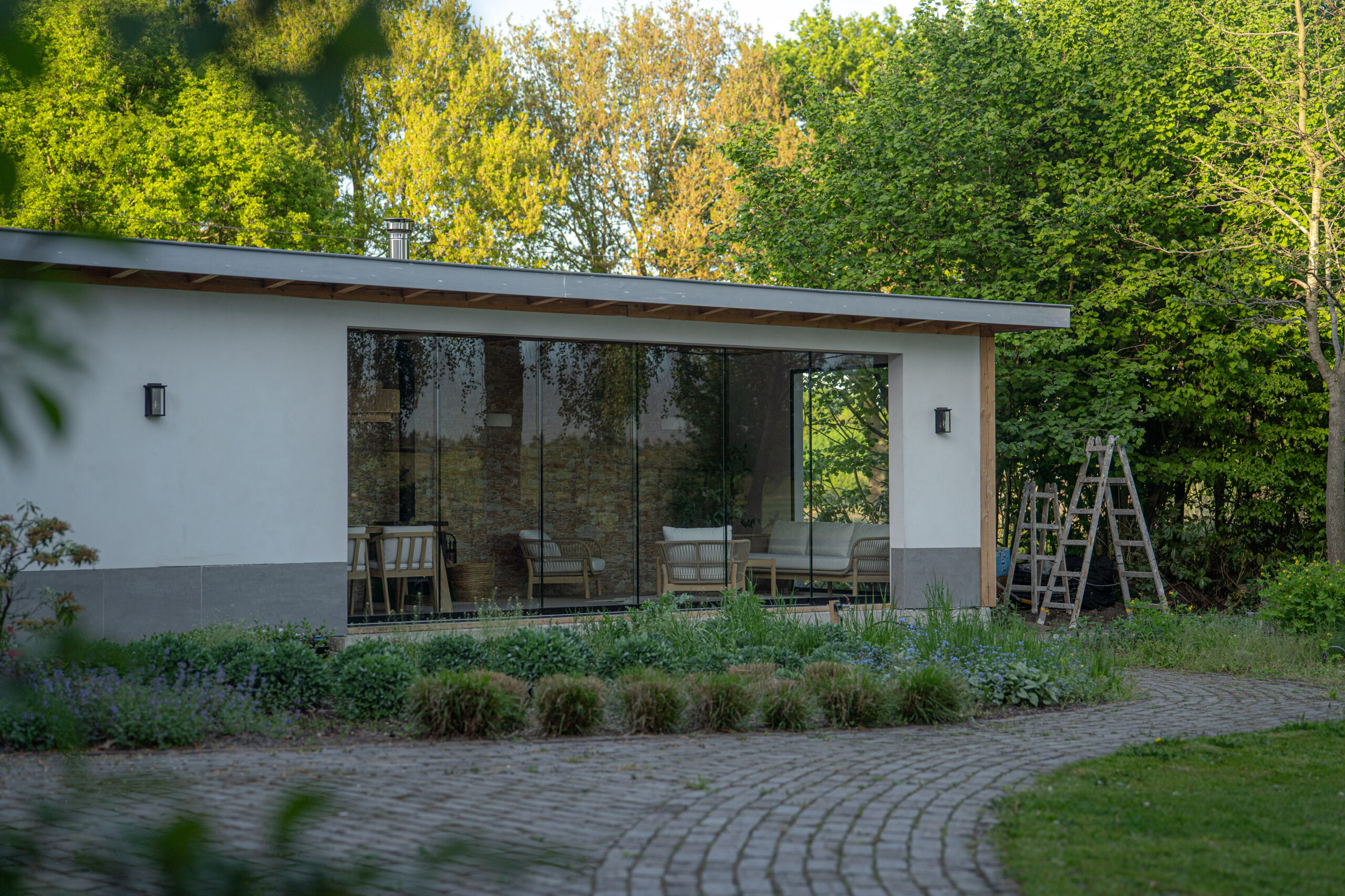 Glazen schuifdeur met antraciet profielen op een veranda