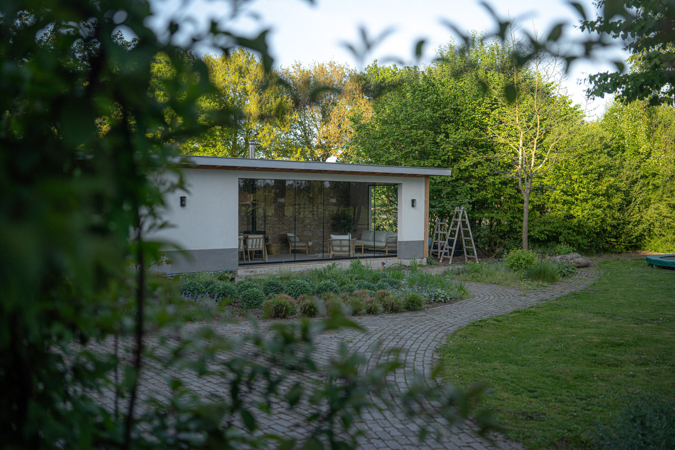 Moderne strakke glazen schuifdeur in lichte tuinkamer